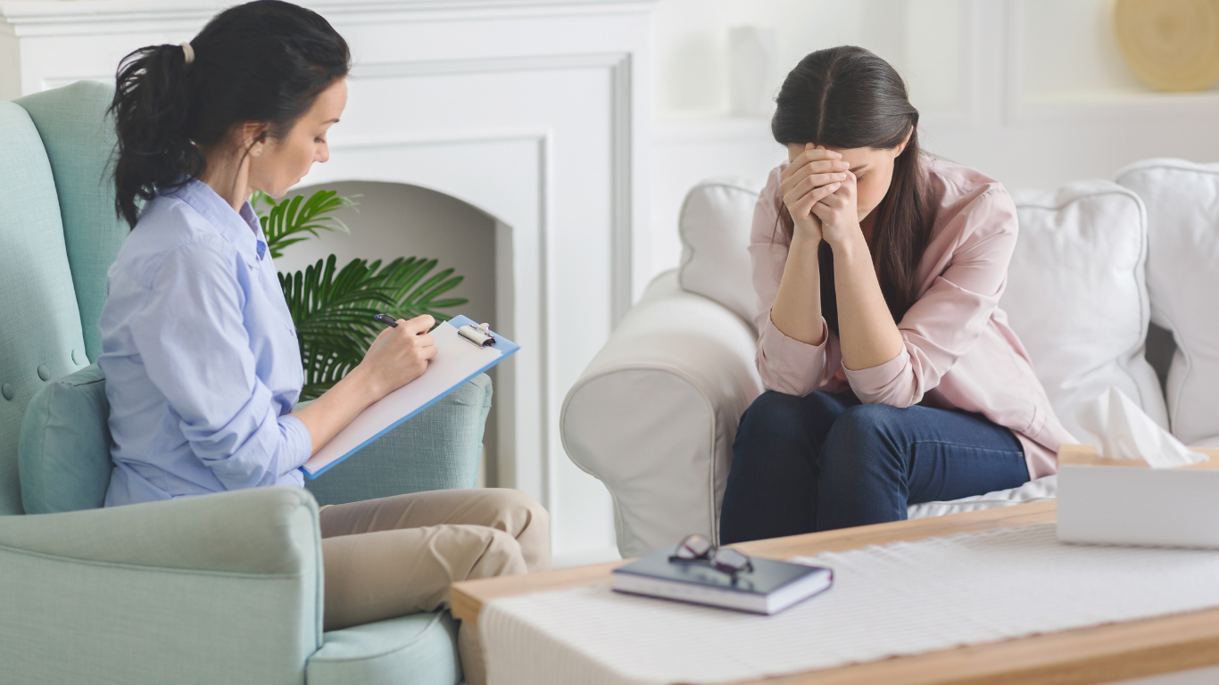A grief therapist in session with a client at Grief Unbound in Saddle River, NJ — warm natural light, skilled and human