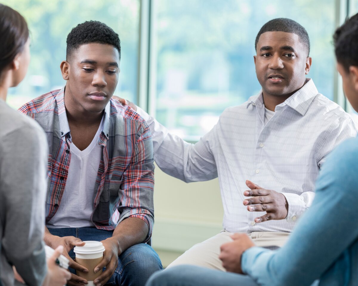 Person in a Bergen County grief support group, listening with eyes closed